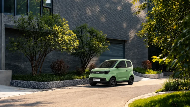 VinFast Minio Green màu xanh ngọc chạy trên con phố nhiều cây xanh