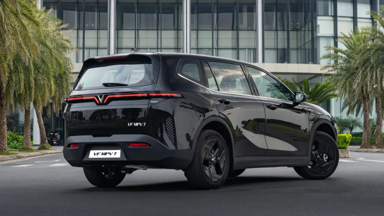 VinFast MPV7 màu đen Jet Black nhìn từ phía sau trước tòa nhà
