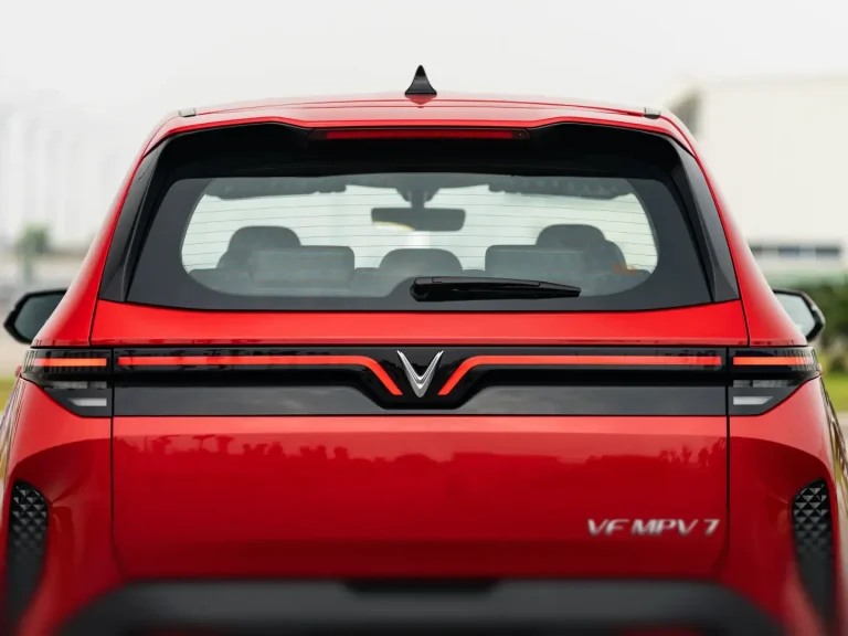 Đuôi xe VinFast MPV7 màu đỏ với dải đèn hậu LED nối liền logo VinFast