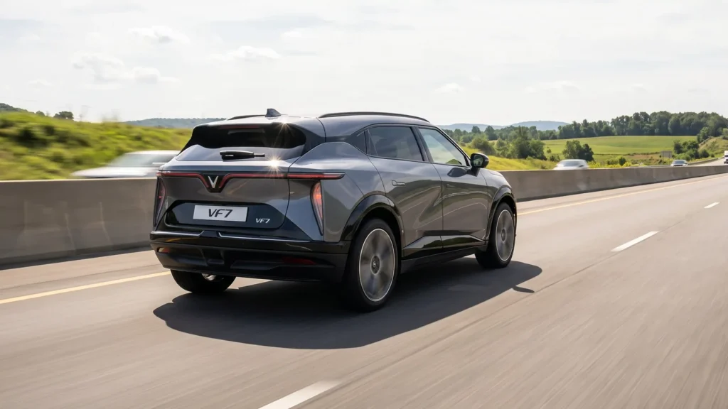 Đuôi xe VinFast VF 7 màu xám dáng coupe chạy trên đường cao tốc