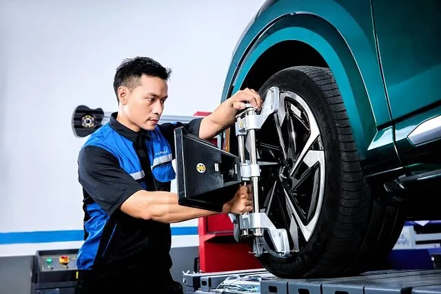 Kỹ thuật viên dịch vụ VinFast kiểm tra bánh xe ô tô điện
