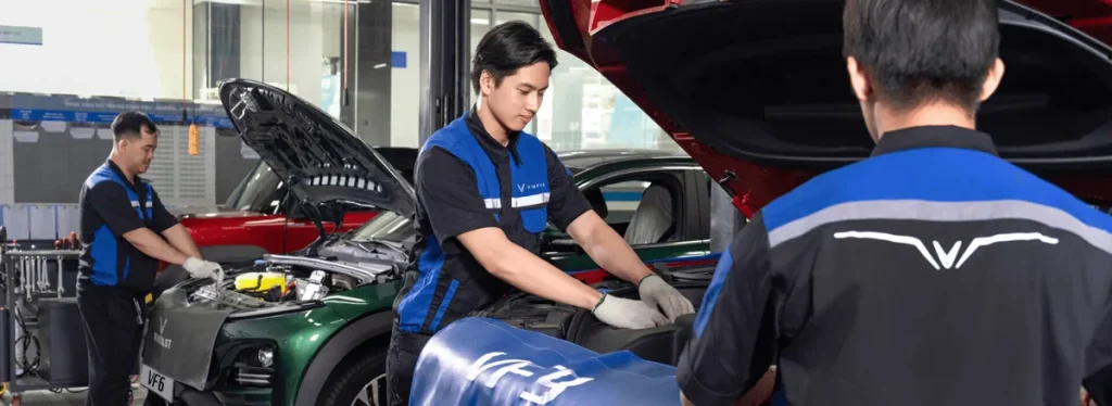 Kỹ thuật viên VinFast kiểm tra khoang động cơ của ô tô điện trong xưởng dịch vụ